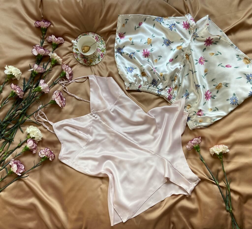 Silk pajamas with floral design and a teacup surrounded by flowers.